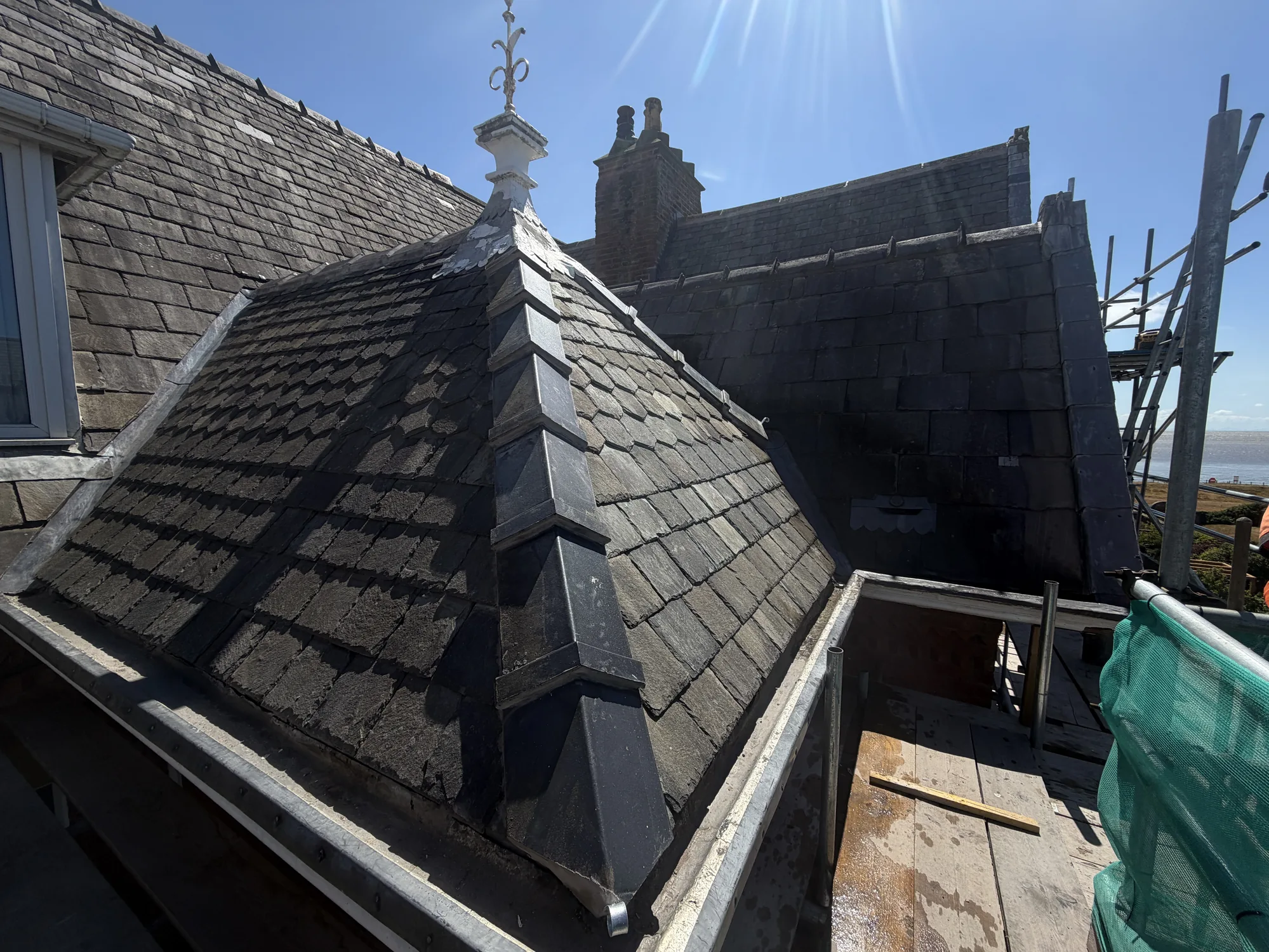 Ornamental slate turret with hand-cut courses and a restored finial