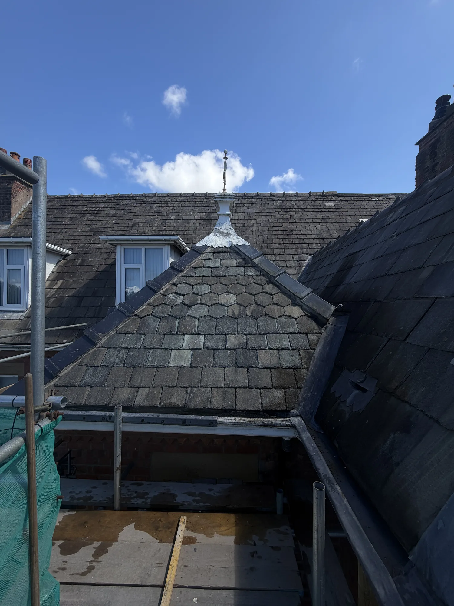 Hand-cut fish-scale slate courses on a character gable