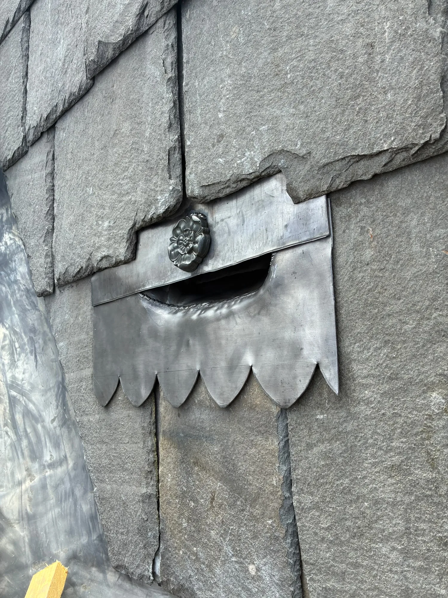 Bespoke decorative leadwork with a hand-formed Tudor rose and scalloped apron