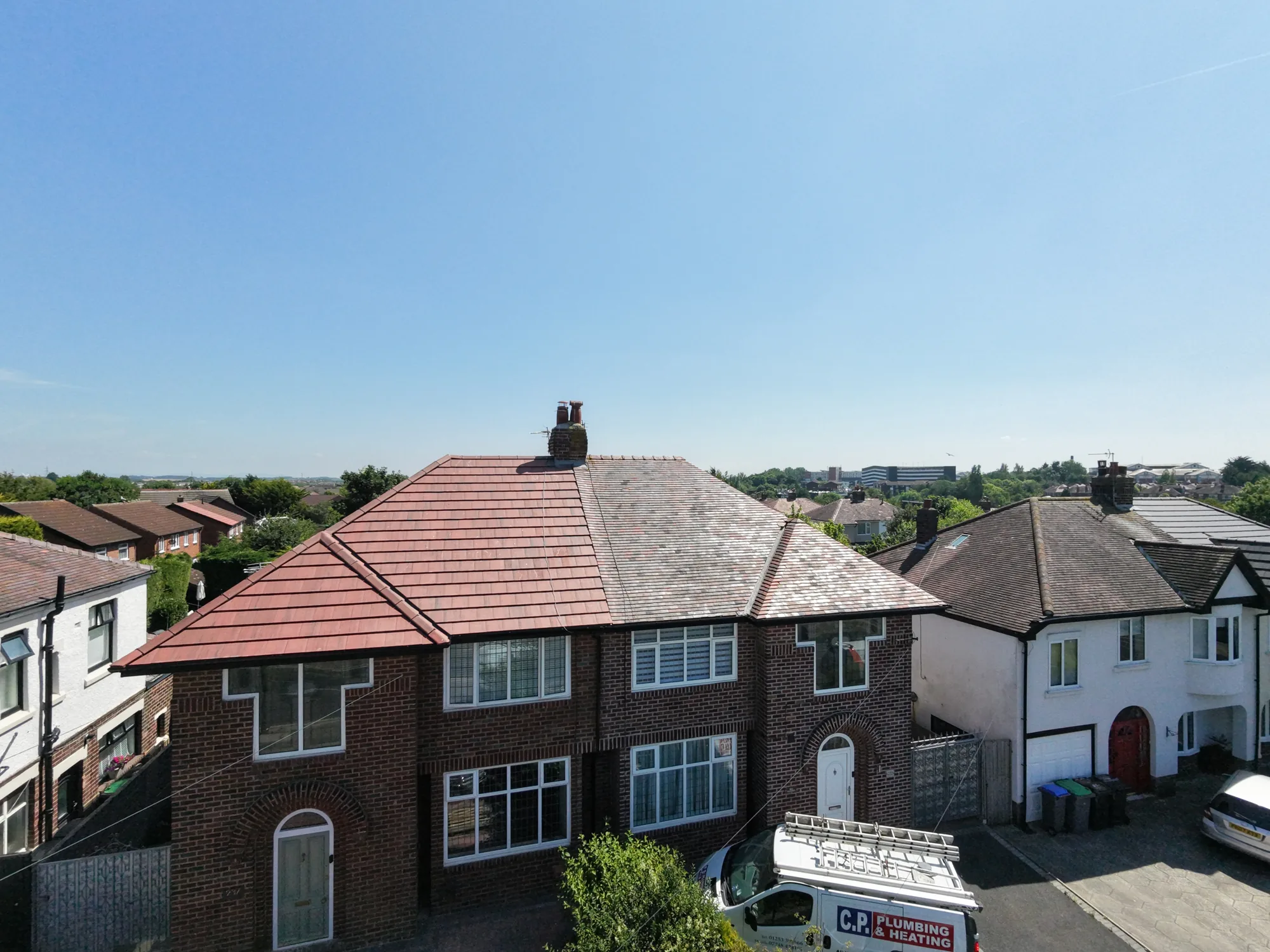 New red tiled roof next to a neighbour's weathered old roof